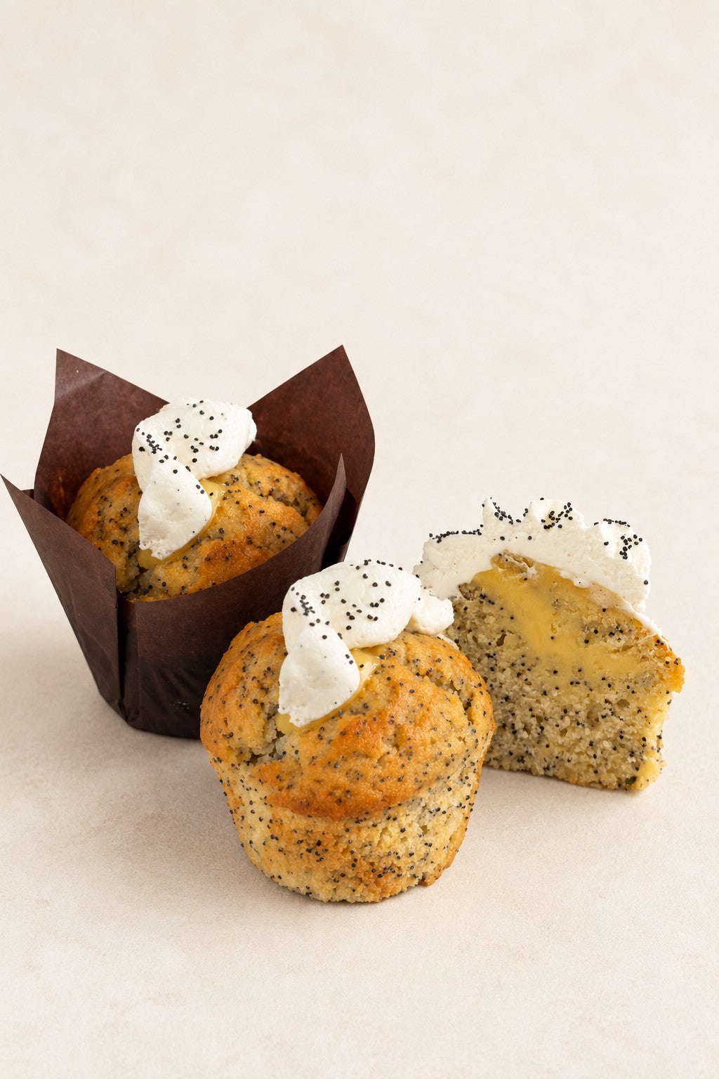 Lemon - Poppy Seed - Yuzu Muffin by Batida - two muffins, with and without a paper case, and a half with curd inside