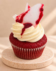 Red velvet muffin with sugar glass and cream, close-up from the side