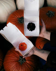 Pumpkin Latte Black i pomarańczowe Pumpkin Latte w pudełkach na tle dyń