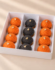 Set of 12 Halloween mini choux pastries, orange and black, in a white box