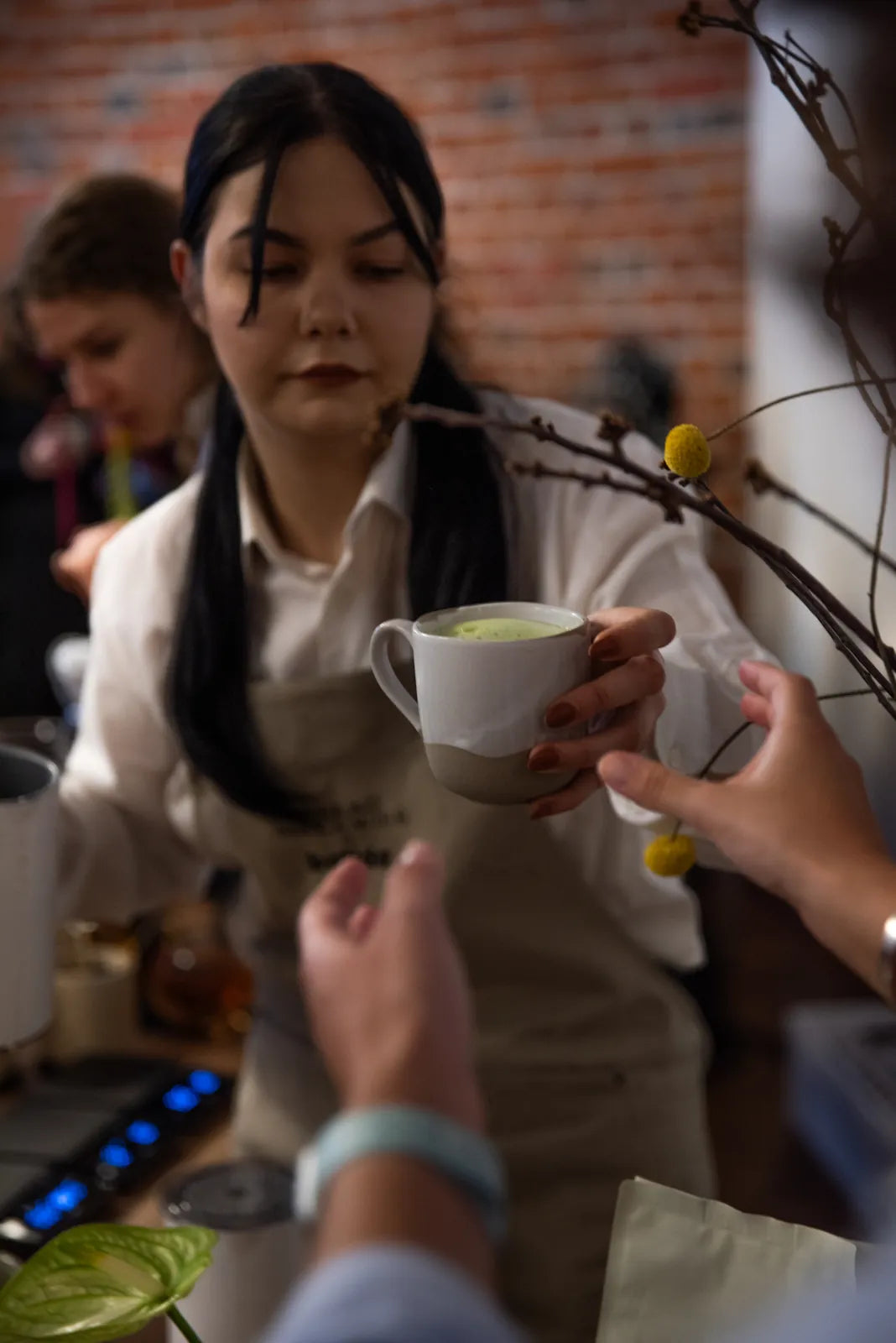 Barista Batidy podaje gościom matcha latte na evencie