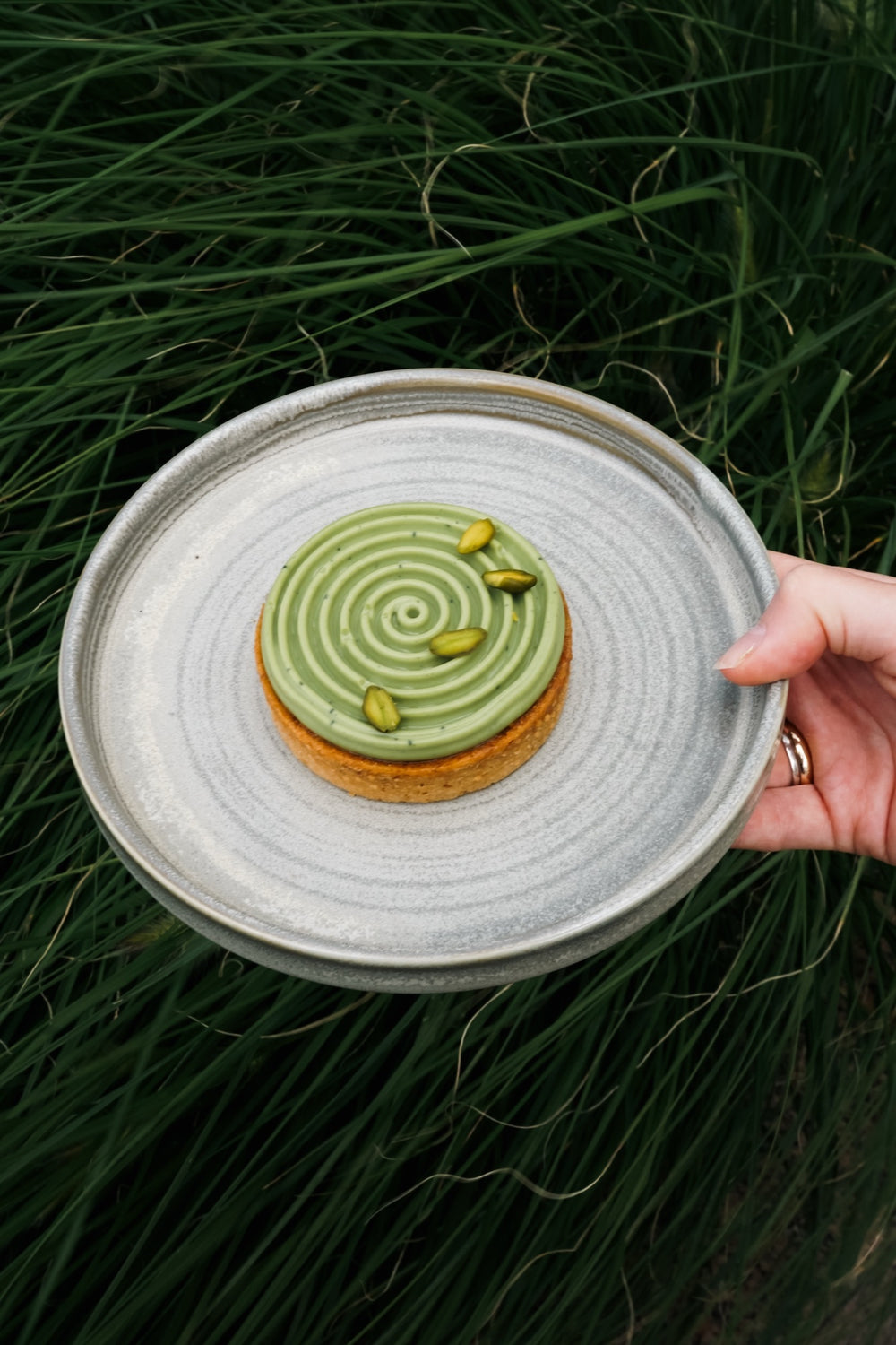 Tartaletka matcha Batida na talerzu na tle traw