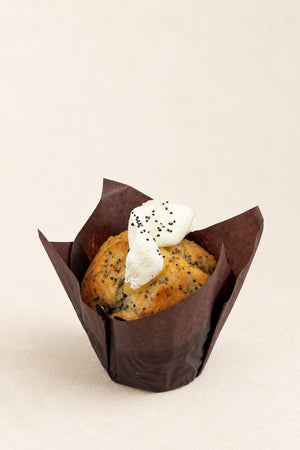 Lemon - Poppy Seed - Yuzu Muffin by Batida - muffin in a brown paper case with cream cheese frosting and poppy seeds