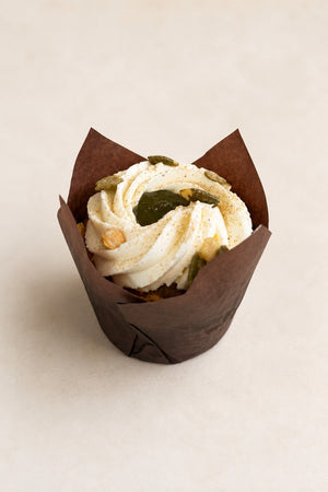 Muffin Carotte à la cardamome de Batida - muffin dans une caissette brune, avec crème et graines de courge