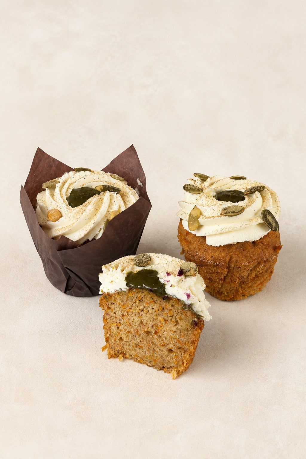 Muffin Carotte à la cardamome de Batida - deux muffins, avec et sans caissette, et une moitié montrant la coupe