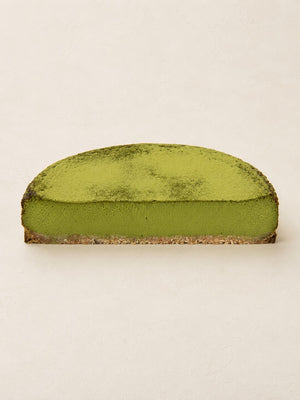 Matcha - White Chocolate Cheesecake by Batida - half a cheesecake from the side, cross-section with the oat base