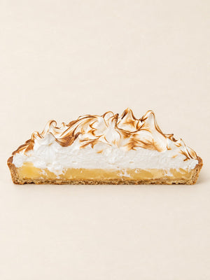 Tarta cytryna - yuzu z opalaną bezą Batida - połówka tarty z boku, widać kruchy spód, curd i bezę