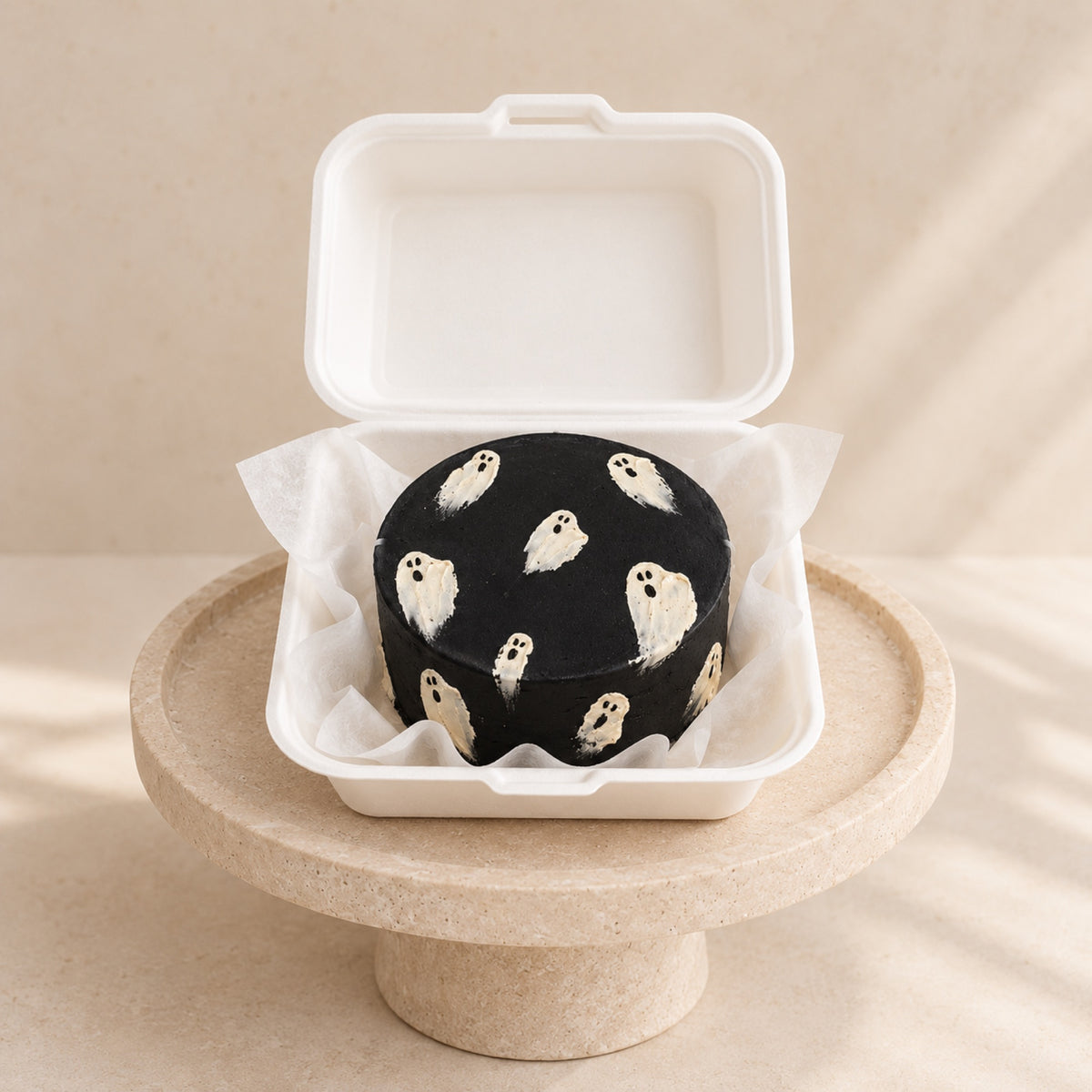 Black bento mini cake with hand-painted ghosts in a box