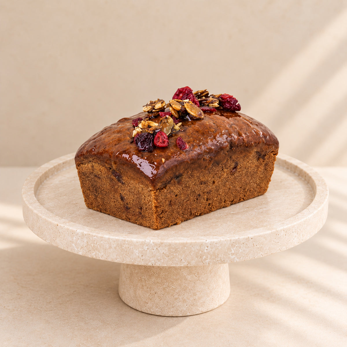Pumpkin bread with cranberries and caramelised pumpkin seeds on a cake stand