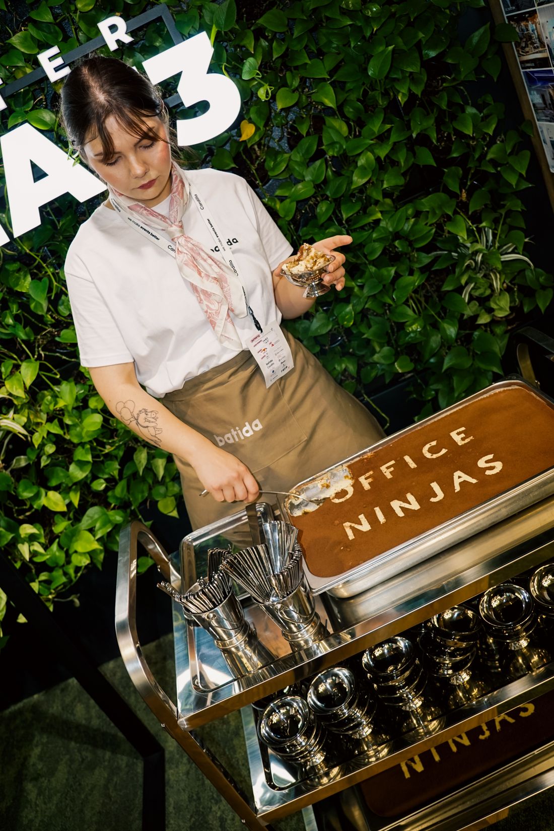 Barista Batidy nakłada tiramisu z wózka z napisem Office Ninjas