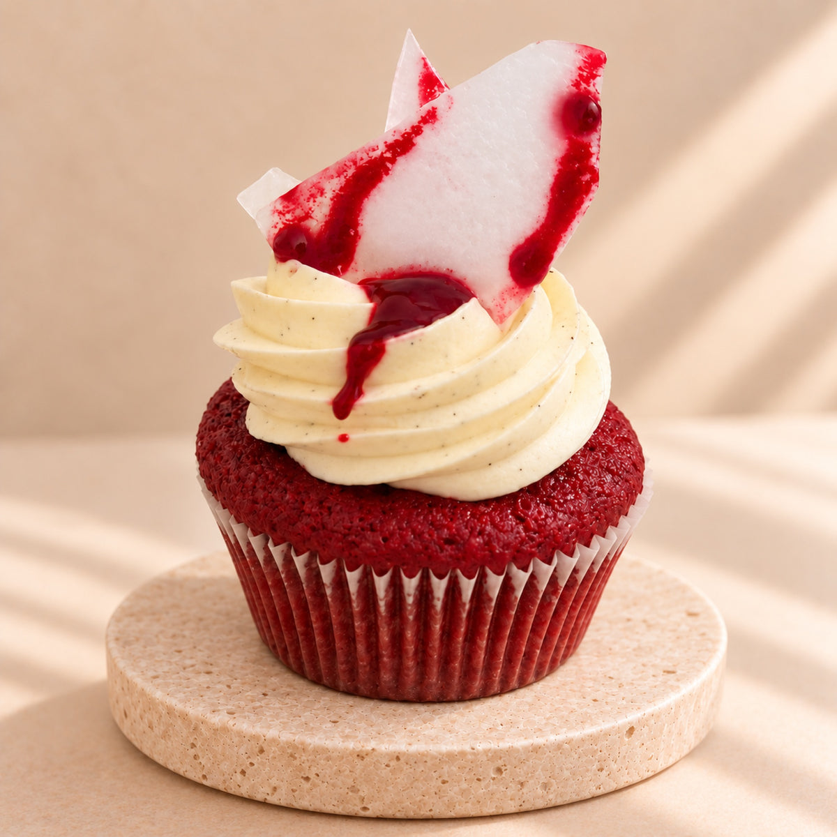 Red velvet muffin with sugar glass and cream, close-up from the side