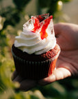 Muffin red velvet Halloween z czerwonym cukrowym szkłem wśród zieleni