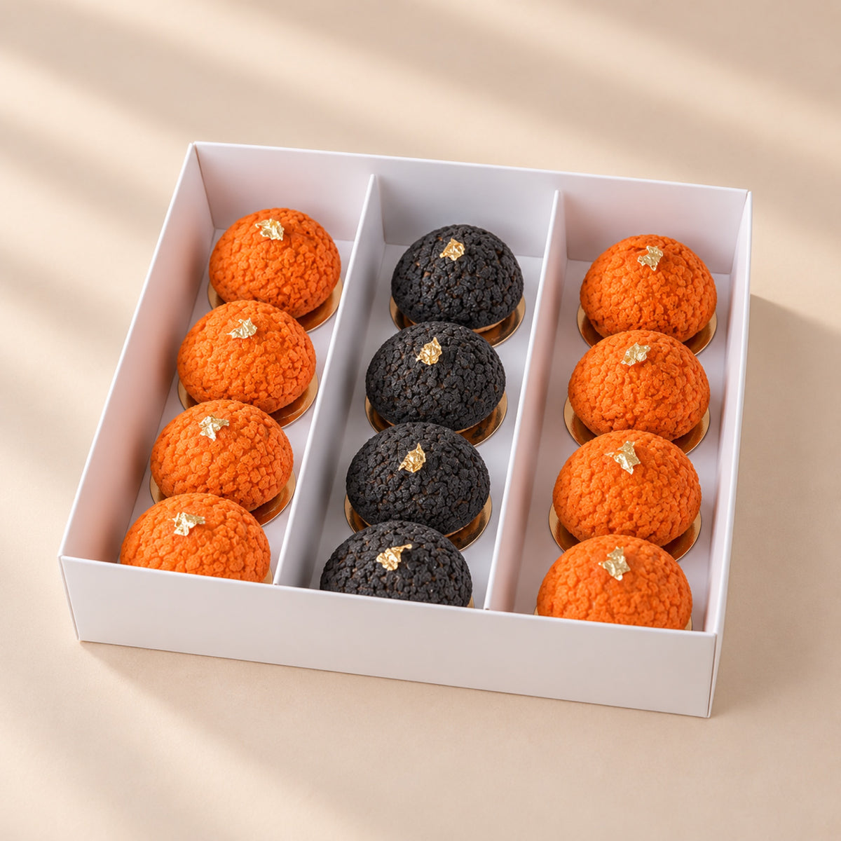 Set of 12 Halloween mini choux pastries, orange and black, in a white box