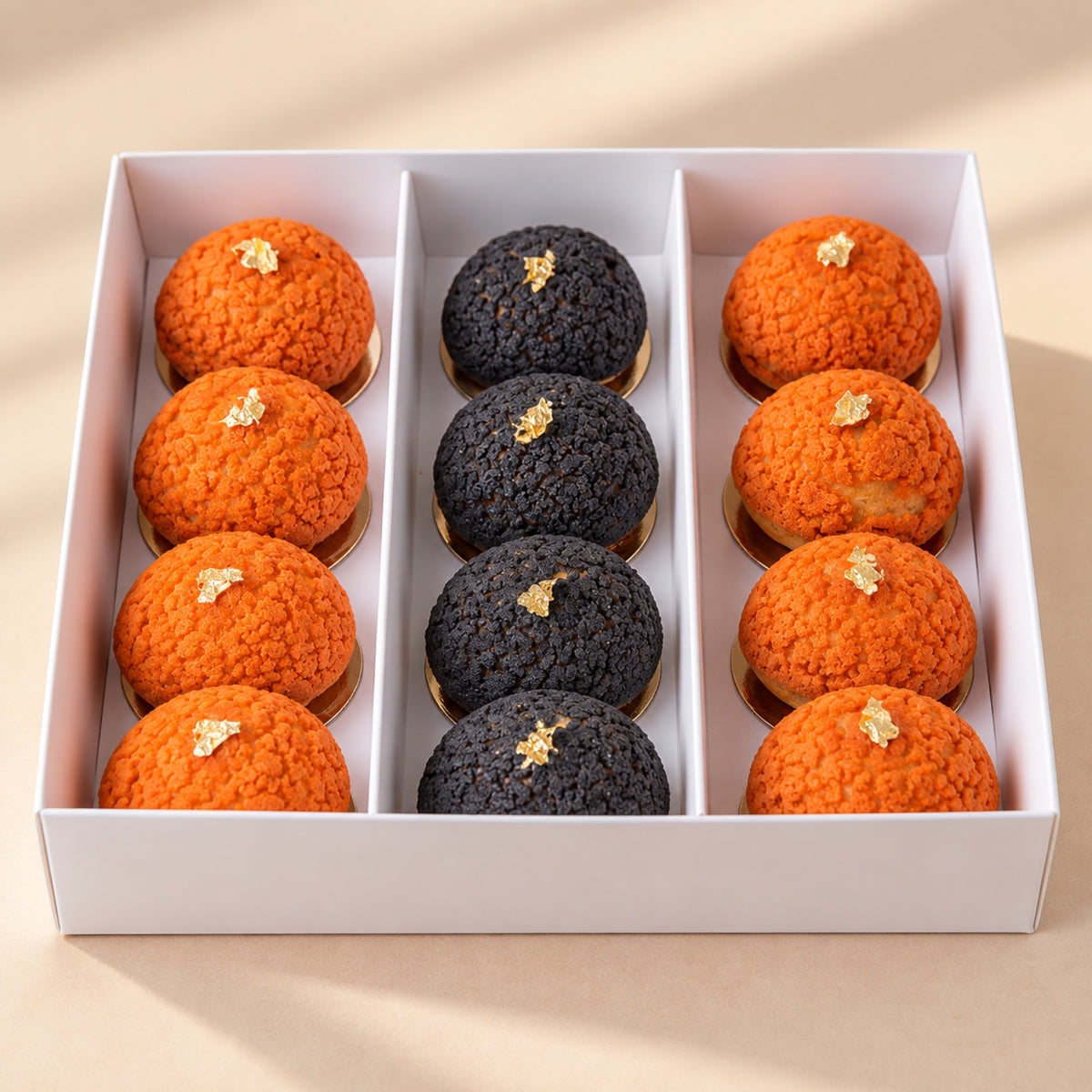Halloween mini choux pastries with gold flakes in a box, top view