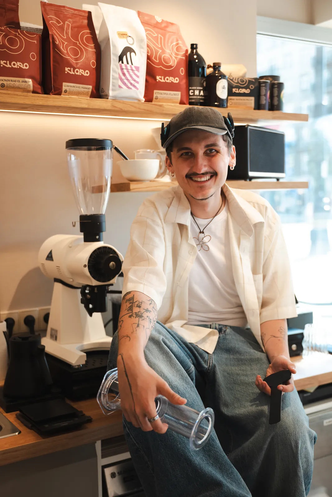 Barista Batidy z kawą z palarni Klaro przy młynku w kawiarni speciality